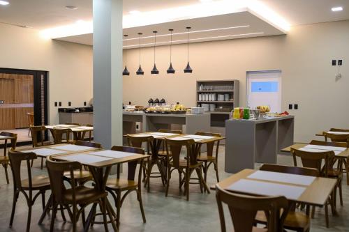 a restaurant with tables and chairs and a kitchen at Amazon Green Hotel in Lucas do Rio Verde