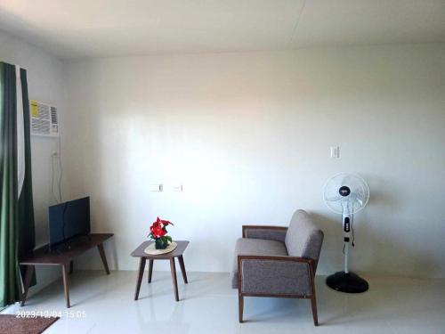 Una sala de estar con un sofá, una silla y una mesa. en Cozy Studio with pool, en Puerto Princesa City