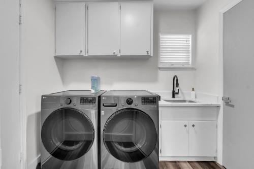 a kitchen with a washing machine and a sink at 10min to EXPO - Family-Friendly with Office & Playroom in Tulsa