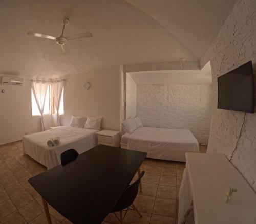 una camera d'albergo con due letti e un tavolo di Hotel El Legendario a Sosúa