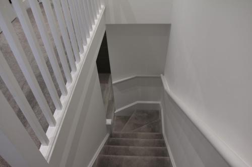 a stairway with white walls and white stairs at Brand new Greenwich house-Heart of London-Great connections to Central London in London