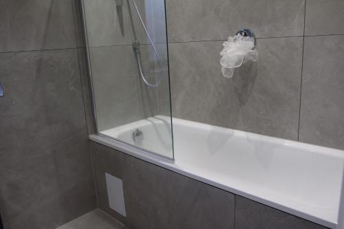 a bathroom with a shower and a bath tub with a glass door at Brand new Greenwich house-Heart of London-Great connections to Central London in London