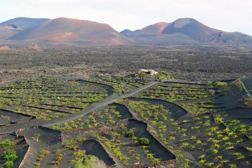an aerial view of a farm with mountains in the background at Casa Rural Vega de Timanfaya in Uga