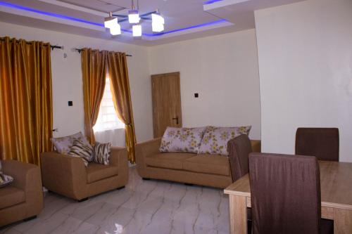 un soggiorno con divano, sedie e tavolo di ODTC Homes and Apartments a Ibadan
