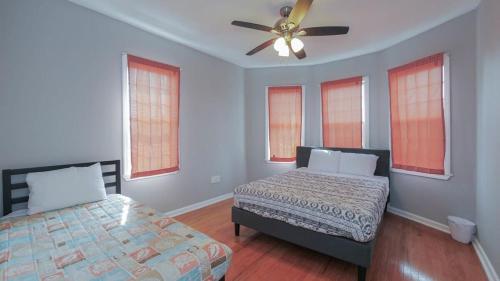 a bedroom with two beds and a ceiling fan at Escape to Raleigh Ave 3 Steps from the Beach in Atlantic City