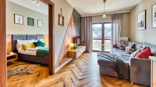 sala de estar con sofá y espejo en Apartament A12 Green Resort z Basenem, Sauną, Jacuzzi - 5D Apartments, en Szklarska Poręba