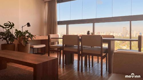 jadalnia ze stołem i krzesłami oraz dużym oknem w obiekcie White 2880 - Pinheiros w São Paulo