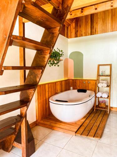 a wooden bathroom with a large white bath tub at Pousada Rural Pavão - Suites e Chalés in Urubici