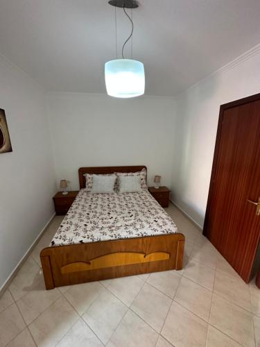 um quarto com uma cama e uma luz por cima em Henry’s beach apartment em Golem