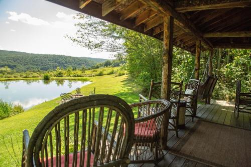 Great ValleyにあるCozy Cottage on Pondの湖の景色を望むポーチ(椅子付)