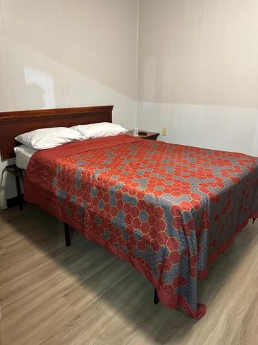モンゴメリーにあるTravel Inn Montgomery ALの赤と青の毛布が備わるベッドルームのベッド1台