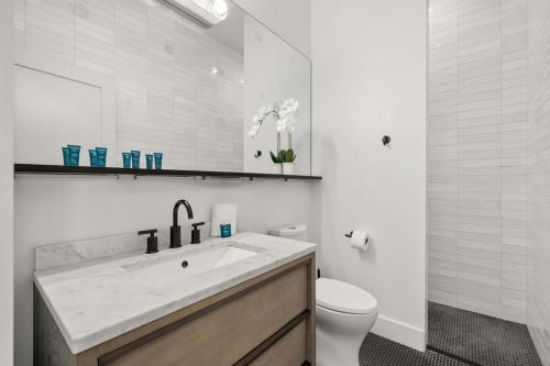 a white bathroom with a sink and a toilet at NEW! Casa Monte Cristo - Upscale Ybor Townhome in Tampa