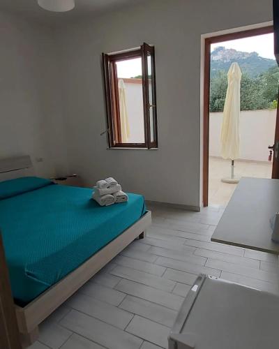 a bedroom with a bed with a mirror and a window at Affittacamere La Ciprea in San Marco di Castellabate