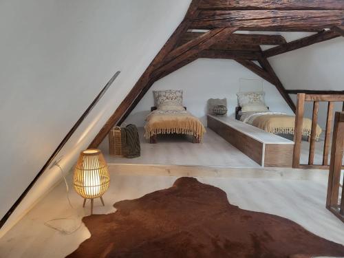 a attic room with two beds and a lamp at Ferienwohnung im Rebstock Nr.1 in Bahlingen