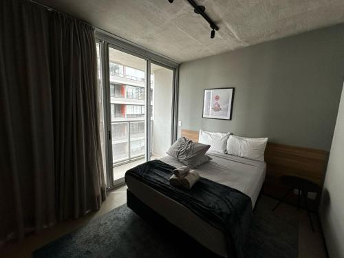 a bedroom with a bed and a large window at Flat Frei Caneca in Sao Paulo