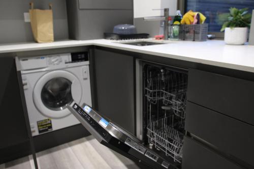 a dishwasher with its door open in a kitchen at Brand new Greenwich house-Heart of London-Great connections to Central London in London