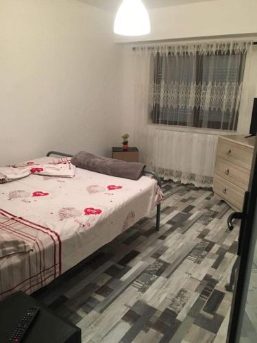 a bedroom with a bed and a dresser and a window at apartament Sara in Mangalia