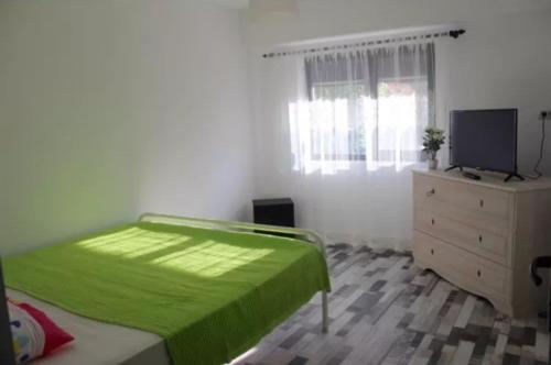 a bedroom with a bed and a dresser and a television at apartament Sara in Mangalia