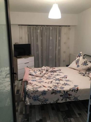 a bedroom with a bed and a dresser and a television at apartament Sara in Mangalia