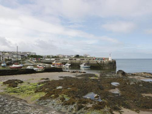 a group of boats are docked at a harbor at Ty Bara in Cemaes Bay