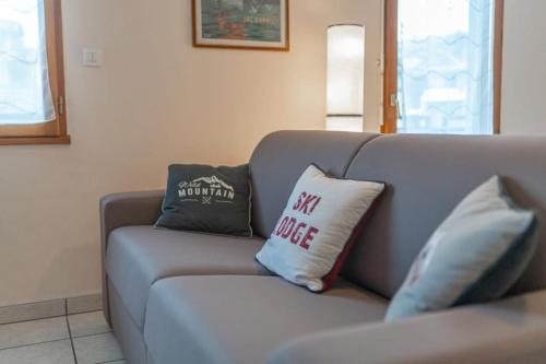 Duas almofadas sentadas num sofá na sala de estar em Mionnaz furnished flat em Epagny Metz-Tessy
