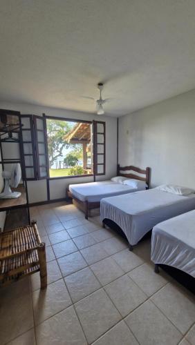 1 Schlafzimmer mit 2 Betten und einem großen Fenster in der Unterkunft Sítio Santa Cruz in Santa Cruz