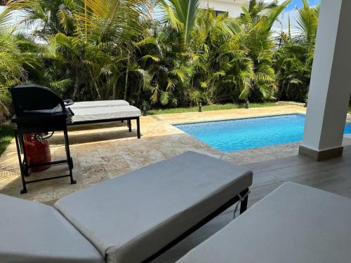 a living room with a couch and a swimming pool at Exclusive Villa * private Beach and Housekeeping in Punta Cana