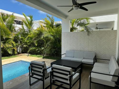 a patio with a table and chairs and a pool at Exclusive Villa * private Beach and Housekeeping in Punta Cana