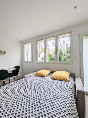 - une chambre avec un grand lit et 2 oreillers jaunes dans l'établissement STOCKHOLM- Studio Cosy et Patio, Proche Centre, à Charleville-Mézières