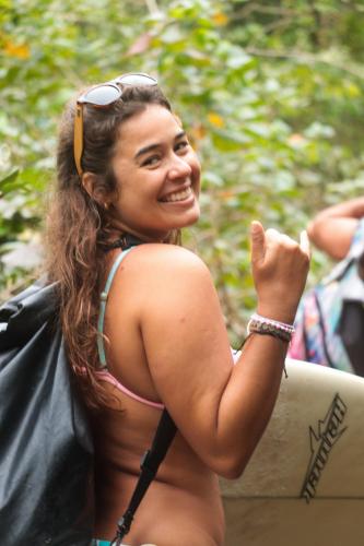 a woman in a bikini holding a surfboard at BASE CAMP, Guest House, Surf House , Itamambuca, Ubatuba in Ubatuba