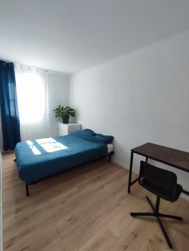 1 dormitorio con cama, escritorio y mesa en CHAMBRE DANS APPARTEMENT LES GRANDS NOELs, en Saint-Sébastien-sur-Loire