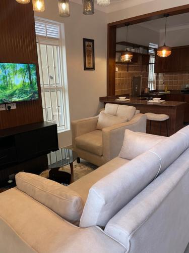 a living room with two couches and a flat screen tv at Athena Apartments in Kampala