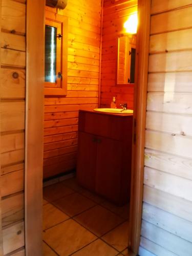 - une salle de bains pourvue d'un lavabo dans une cabine en bois dans l'établissement Chalet California Dreamin Route 66, à Casteil