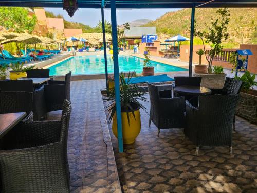 a swimming pool with chairs and a table and a swimming pool at Auberge le Refuge in Agadir