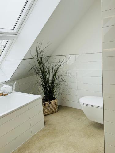 a bathroom with a sink and a toilet and a plant at Sievershof Poolloft in Wietzendorf