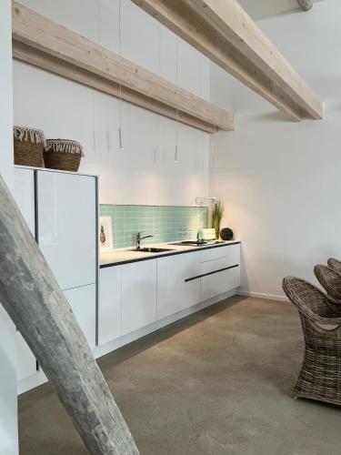 a kitchen with white cabinets and a sink at Sievershof Poolloft in Wietzendorf