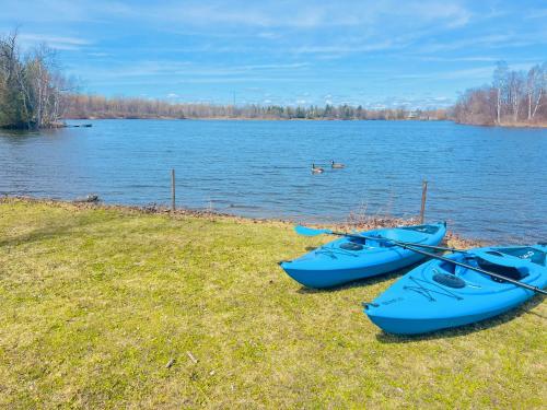 three kayaks sitting on the shore of a lake at Breezes Park in Acton