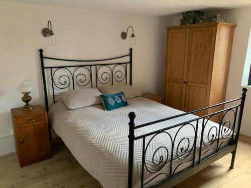 1 dormitorio con cama negra y almohada azul en La bergerie en Quillan