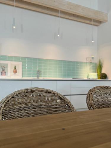 a kitchen with a wooden table and two chairs at Sievershof Poolloft in Wietzendorf