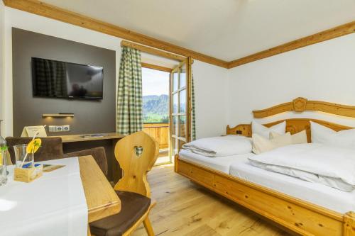 um quarto de hotel com duas camas e uma mesa e cadeiras em Demelhof em Reit im Winkl