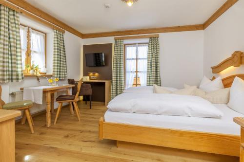 a hotel room with a bed and a desk at Demelhof in Reit im Winkl