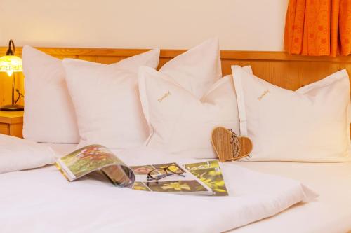 a bed with white pillows and a magazine on it at Demelhof in Reit im Winkl