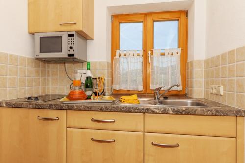 a kitchen with a sink and a microwave at Demelhof in Reit im Winkl