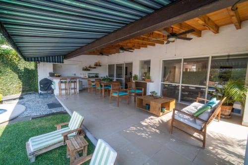 un patio con sillas y una mesa y una cocina en 4BR House in Santa Fe Golf Club with Wifi and Pool, en Alpuyeca