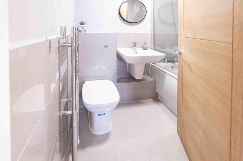 uma casa de banho branca com um WC e um lavatório em Bright 2-bed Flat in Central Reading em Reading