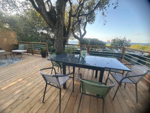 a patio with a table and chairs on a deck at MOBIL HOME saint Raphael camping l’île d’or in Saint-Raphaël