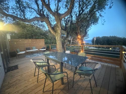 a table and chairs on a deck with a tree at MOBIL HOME saint Raphael camping l’île d’or in Saint-Raphaël