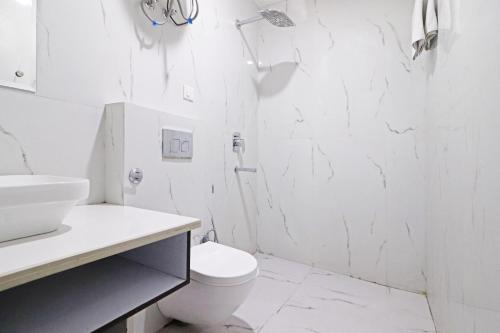 uma casa de banho branca com um WC e um chuveiro em Galaxy Stay Hotel Near Delhi Airport em Nova Deli