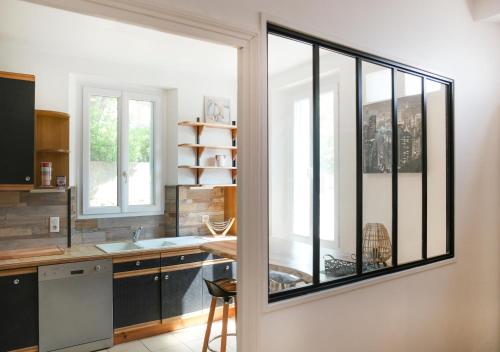 uma cozinha com uma grande janela e um lavatório em Pamiers gare - 2 Appartements à louer ou Chambre parentale indépendante em Pamiers