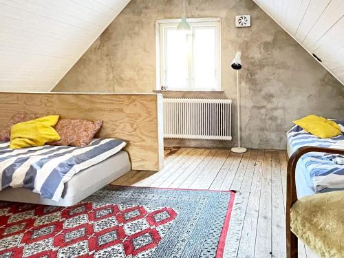 a attic room with a bed and a window at Holiday home HÖGANÄS in Höganäs